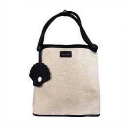 A large, beige shoulder bag with a black strap and a black pom-pom accent. The bag appears to be made of a textured, canvas-like material and has a simple, minimalist design.