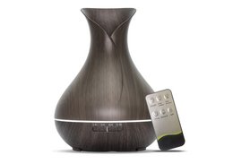 Dark wood aroma diffuser with remote control, ideal for essential oil diffusion in home or office.