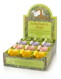 Sheep-shaped soap bars in a variety of pastel colors, displayed in a wooden crate. The soap bars appear to be handmade and natural, with a rustic, organic aesthetic.