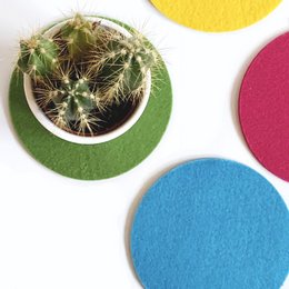 Round felt coasters in a variety of vibrant colors including pink, yellow, blue, green, black, camel, gray, and orange.