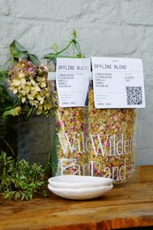 Ceramic tray for serving tea, featuring a rustic, natural design with a mix of dried flowers and herbs. The tray has an earthy, organic appearance that complements the Wilder Land Tea Offline product.