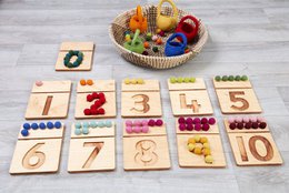  Cosy Viltbal Nummerbak Pakket - Set of 11 wooden number toys in various shapes and colors, suitable for early learning and counting.
