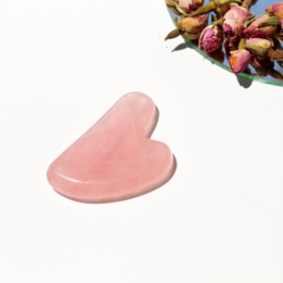Heart-shaped rose quartz gua sha tool for facial massage and skin care. Made of natural rose quartz stone with a smooth, heart-shaped design.