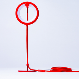 Minimalist, portable desk lamp with circular design in blue, grey, and olive green color variants.