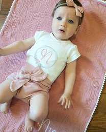 Powder pink baby bloomers with a bow. Soft, comfortable fabric. Adorable monogram design. Perfect for infants and toddlers.