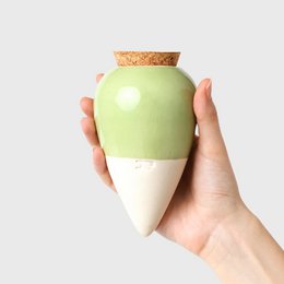 A green, ceramic, teardrop-shaped planter with a cork lid. The planter has a smooth, glossy finish and a simple, minimalist design.