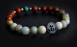Colorful beaded bracelet with a charm featuring a paw print design, made of natural stones in various earthy tones.
