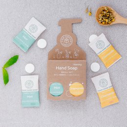 Hand soap tablets in mint and chamomile scent, packaged in a wooden tray with additional soap products.