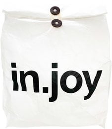 A white gift bag with the text "in.joy" printed in black. The bag has two black buttons on the front.