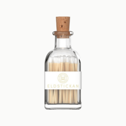 Small white matches in a clear glass bottle with a wooden cap.