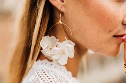 Large white floral statement earrings with gold hoops. Elegant and feminine design.
