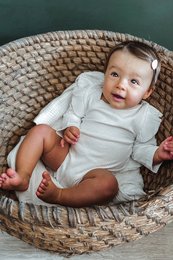 White ruffle romper for baby, available in sizes 0-3m, 3-6m, 6-12m, 12-18m. Made of soft, comfortable material. Ideal for casual, everyday wear.