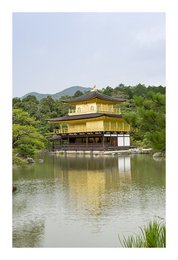 Ornate golden pavilion surrounded by lush greenery and reflecting in a tranquil pond.