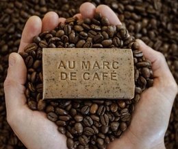 A bar of coffee-scented Marseille soap made from coffee grounds, with the text "AU MARC DE CAFE" printed on it.