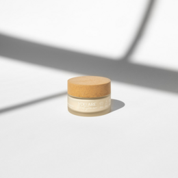 Natural lightweight moisturizer in a beige jar with a wooden lid.