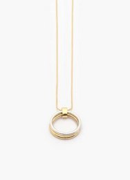 Elegant gold-tone necklace with a simple circular pendant in a minimalist design.