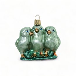 Three green chicks on a grassy meadow ornament. Colorful glass ornament with intricate details.