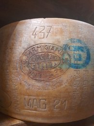 Aged Parmigiano Reggiano DOP cheese, 24 months matured, with distinctive markings and texture.