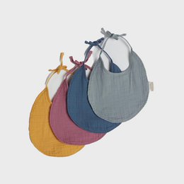 Organic cotton muslin bibs in a set of 4, featuring a variety of soft, neutral colors including yellow, pink, gray, and navy. The bibs have a simple, minimalist design with a snap closure for easy use.