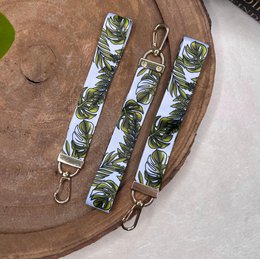 Tropical leaf-patterned lanyard with gold-tone hardware.