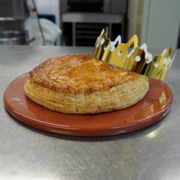 Rectangular metal oven tray with a golden-brown baked pastry on a red plate.