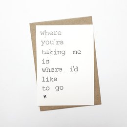 A greeting card with a simple, whimsical text that reads "where you're taking me is where i'd like to go". The card has a minimalist design with a plain white background and a handwritten-style font.