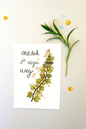 A handwritten note on a white background with a sprig of yellow flowers and green leaves. The note reads "Nicht so einfach weg" which means "Not so simple away" in German.