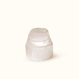 A tall, cylindrical selenite tower tea light candle holder with a soft, natural glow.