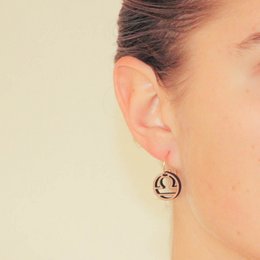 Libra earrings in silver and gold-plated silver. Circular hoop design with Libra symbol.