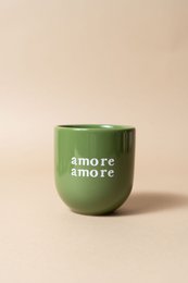  Green ceramic cup with "amore amore" text. Cylindrical shape with a glossy finish.