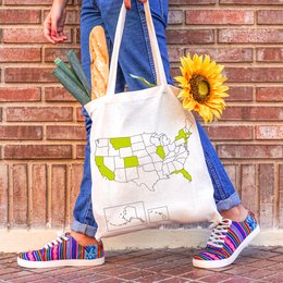 "USA Tote Bag - Beige canvas tote bag with a map of the United States printed on it. Durable and reusable for shopping or travel."