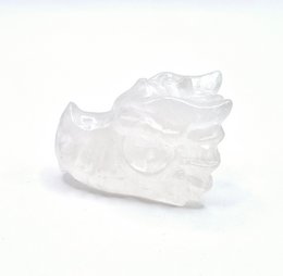  A small, clear crystal dragon skull figurine made from rock crystal. The skull has a detailed, textured surface and a unique, natural shape.