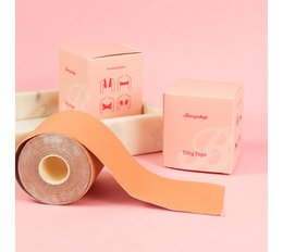 Boozyshop Titty Tape is a pink face mask product. The product packaging features a roll of pink tape with icons depicting different bra styles.