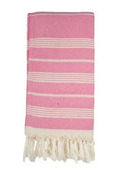 A pink and white striped hammam towel with tasseled edges. The towel has a textured diamond pattern and the brand name "Beachie Blanes" is visible on the tag.