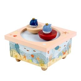 Colorful wooden music box with ocean-themed design, featuring a red and blue spinning top and a blue rattle. Suitable for babies and young children.