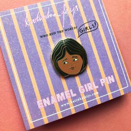  A hard enamel pin featuring the face of a young girl with dark hair and a confident expression. The pin is labeled "Independent Girl Pin" and is part of a collection celebrating girls and women.