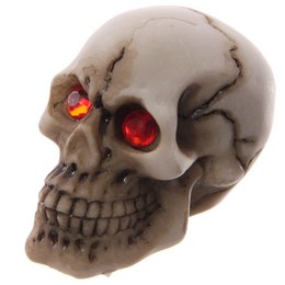 Gruesome skull decoration with red gem eyes, suitable for Halloween or gothic decor.