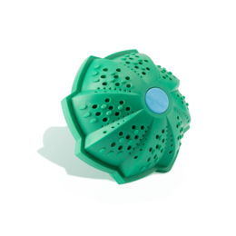 A green, spherical eco wash ball with perforations, floating in water with splashing.