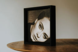  Wooden frame for 12-inch vinyl record album art, available in natural, dark brown, white oil, white, blackened oak, and matte black finishes, freestanding or wall-mountable.