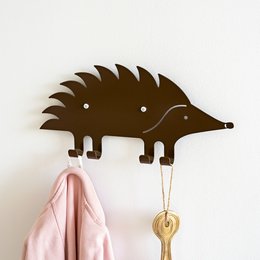 Brown hedgehog-shaped wall hook for hanging kids' clothing and accessories.