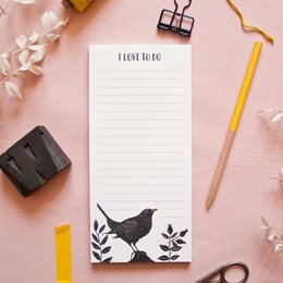 A black and white notepad with a silhouette of a bird and leaves, suitable for writing notes or to-do lists.