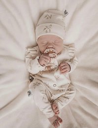 Cozy sand-colored ribbed jersey baby suit with a soft, plush texture and a comfortable hooded design.