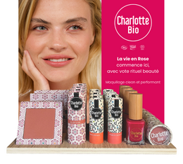  A multi-product display featuring various makeup products from the Charlotte Bio brand, including nail polish in a vibrant pink shade.