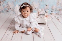 White lace dress for special occasion, suitable for girls aged 6-12 months. Features ruffled collar and sleeves, with delicate floral embroidery.
