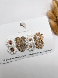 Glittery gold heart-shaped hair clip with white daisy flowers, perfect for kids' hairstyles.