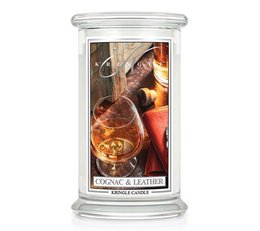 Large scented candle with notes of cognac and leather. Tall, round glass container with a warm, amber-colored wax.