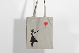 White canvas tote bag with Banksy's iconic 'Balloon Girl' graffiti art printed on the front. Durable and stylish for everyday use.