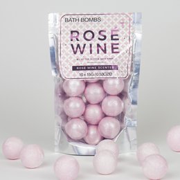 Rose-scented bath bombs in a pink color, packaged in a clear plastic bag.