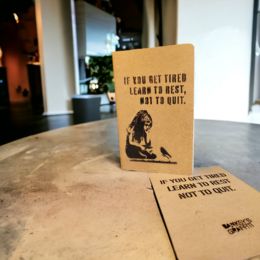 A5 street journal with Banksy stencil, featuring a quote about learning to rest. The journal has a textured cover and appears to be made of recycled materials.