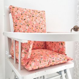 Soft, plush cushion in a vibrant floral pattern, designed to fit a baby highchair for comfort and style.